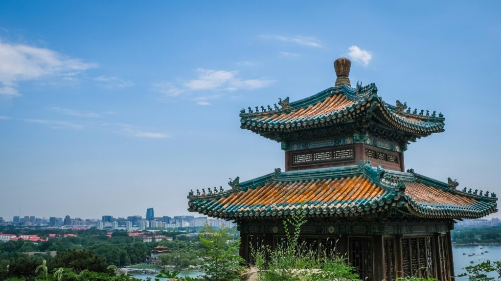 pexels-photo-2846076-2846076 A traditional pavilion in Beijing with the city skyline visible, under clear blue skies.