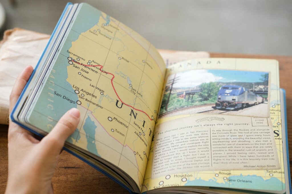 Close-up of a book showing a USA map with West Coast train routes and a train photo.